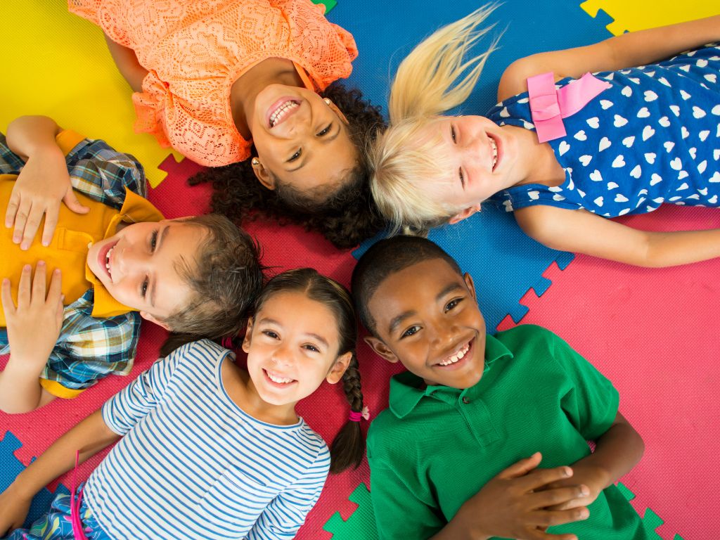  A diverse group of young children sitting in a circle and smiling together